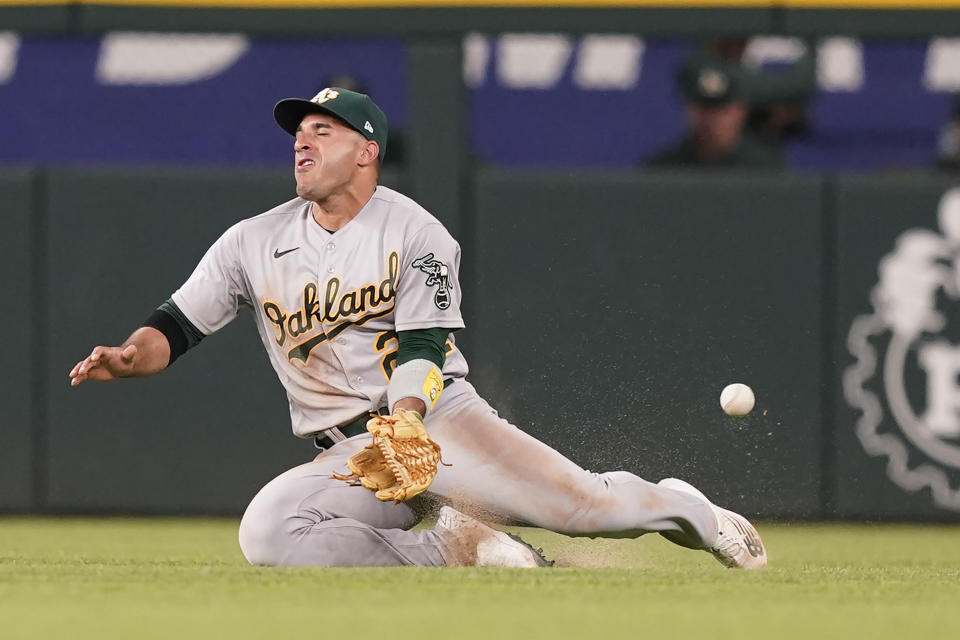 Oakland Athletics center fielder Ramon Laureano cannot handle a ball hit by Texas Rangers' Josh Smith allowing an inside-the-park home run during the sixth inning of a baseball game in Arlington, Texas, Monday, July 11, 2022. Rangers' Leody Taveras also scored on the play. (AP Photo/LM Otero)