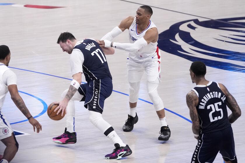 Dallas Mavericks' Luka Doncic (77) is fouled by Los Angeles Clippers' Russell Westbrook, right, during the second half of Game 2 of an NBA basketball first-round playoff series in Dallas, Friday, April 26, 2024. (AP Photo/Tony Gutierrez)