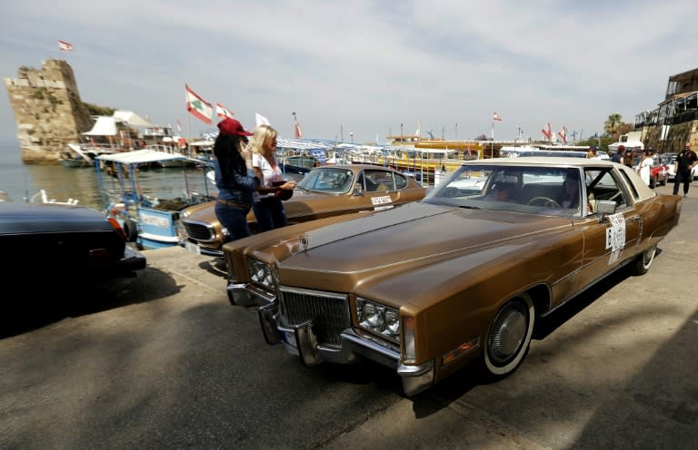 Drivers inspect cars taking part in the "Rallye des Graces" in the Lebanese coastal city of Byblos, north of Beirut, on May 19, 2018