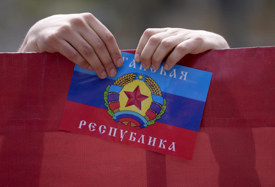 A man holds a flag of the self-proclaimed Donetsk People's Republic during a May Day rally on International Workers Day in Belgrade, Serbia, Sunday, May 1, 2022. Workers and activists marked May Day with defiant rallies and marches for better pay and working conditions. (AP Photo/Darko Vojinovic)