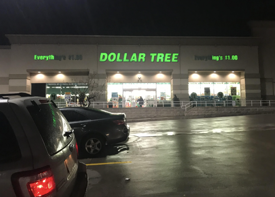 A Dollar Tree store at night with cars parked outside. The store's sign says "Everything's $1.00"
