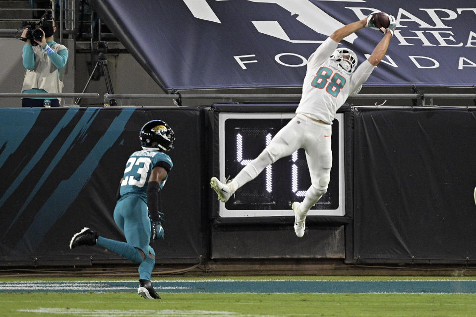 Miami Dolphins tight end Mike Gesicki (88) makes a reception in front of Jacksonville Jaguars cornerback C.J. Henderson (23) during the first half of an NFL football game, Thursday, Sept. 24, 2020, in Jacksonville, Fla. (AP Photo/Phelan M. Ebenhack)