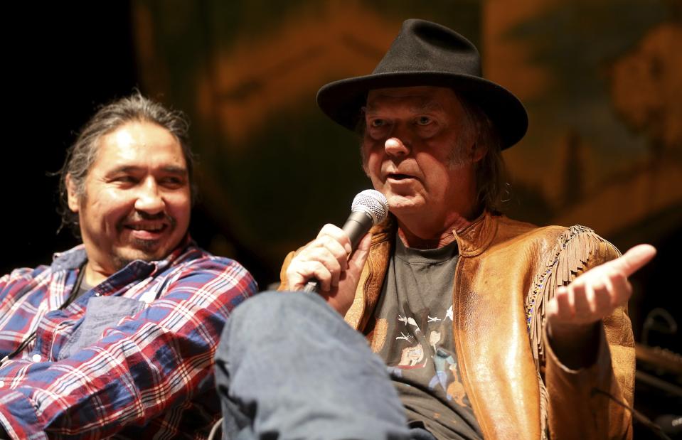 Musician Neil Young addresses the media as Athabasca Chipewyan First Nation Chief Adam looks on before the "Honor The Treaties" concert series in Winnipeg