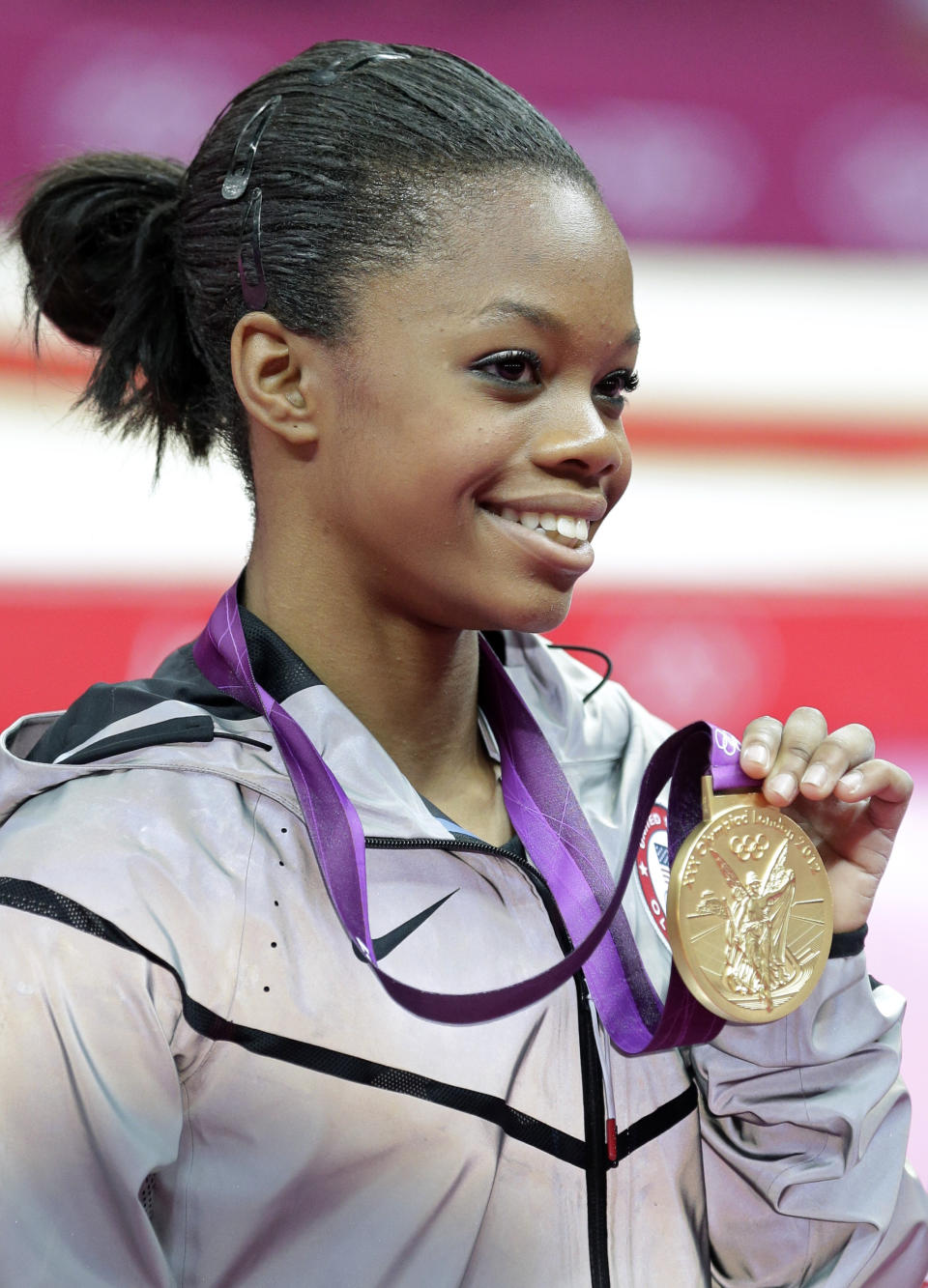 FILE - This Aug. 2, 2012 file photo shows U.S. gymnast Gabrielle Douglas displaying her gold medal during the artistic gymnastics women's individual all-around competition at the 2012 Summer Olympics in London. Douglas became the first African American woman to win Olympic gold in the individual all-around. The feat was joyous, but some on social media bemoaned that her hair wasn't perfect. (AP Photo/Gregory Bull, File)