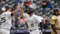 Colorado Rockies' Jacob Stallings, left, congratulates Hunter Goodman, who returns to the dugout after hitting a three-run home run off San Diego Padres relief pitcher Wandy Peralta during the eighth inning of a baseball game Thursday, April 25, 2024, in Denver. (AP Photo/David Zalubowski)