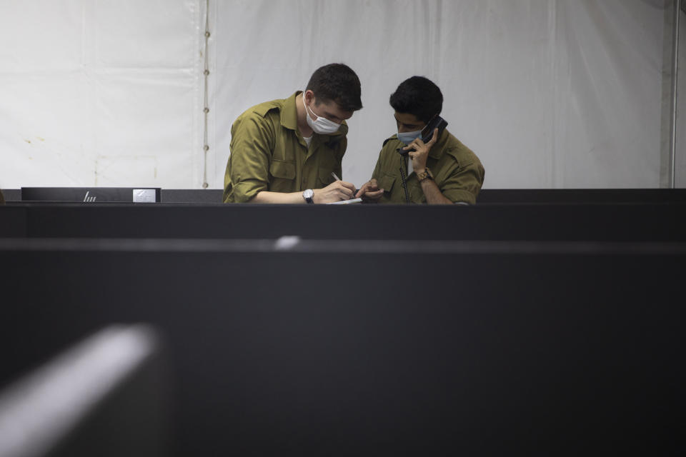 An Israeli soldier interviews a person infected with coronavirus by phone to identify who the person has been in contact with, at the headquarters of the Home Front Command, in Ramle, Central Israel, Tuesday, Aug. 25, 2020. As Israel struggles to control a coronavirus outbreak, it is calling in the army to help. At the instruction of the country's coronavirus czar, the military has set up a new "task force” that is playing a leading role in contact tracing and breaking the chain of infections. (AP Photo/Sebastian Scheiner)