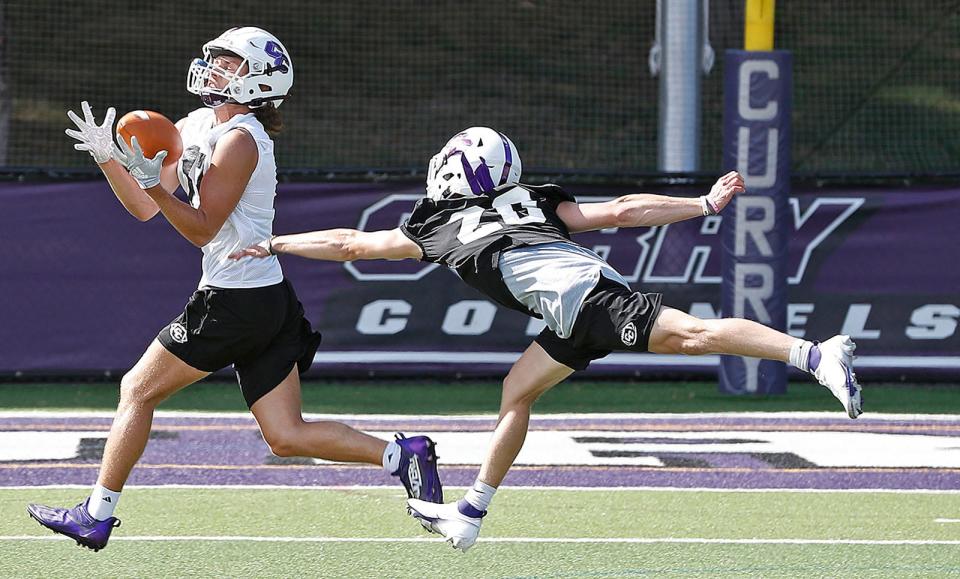 Receiver Joe Fusaro makes a catch against safety Rocco MacNeil during a Curry College football practice on Friday, Aug. 12, 2022.