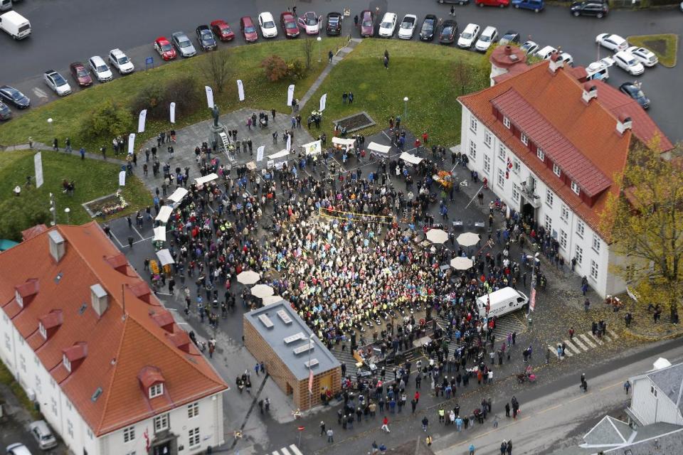 A crowd forms, those in the centre bathing in sunlight, for the official opening of giant sun mirrors in the town of Rjukan, Norway, Wednesday, Oct. 30, 2013. Residents of the small Norwegian town of Rjukan have finally seen the light. Tucked in between steep mountains, the town is normally shrouded in shadow for almost six months a year. But on Wednesday faint rays from the winter sun for the first time reached the market square thanks to three 183-square-foot (17-square-meter) mirrors placed on a mountain. (AP Photo/NTB Scanpix, Terje Bendiksby) NORWAY OUT