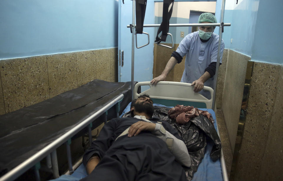 A nurse assists a wounded man in a hospital in Kabul, Afghanistan, Monday, Jan. 14, 2019. Afghan officials say multiple people were killed when a suicide bomber detonated a vehicle full of explosive in the capital Kabul on Monday. (AP Photo/Massoud Hossaini)