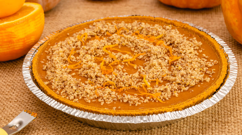 Pumpkin pie topped with crushed nuts and orange zest