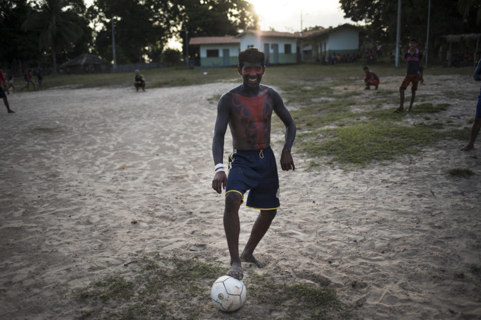 In this Sept. 3, 2019 photo, indigenous Tembé jokes around while dribbling a soccer ball at the Tekohaw indigenous reserve, Para state, Brazil. President Jair Bolsonaro has argued that such large reserves have hindered Brazil’s economic interests. But the indigenous people of Latin America’s largest economy have everything at stake. (AP Photo/Rodrigo Abd)