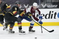 Colorado Avalanche defenseman Cale Makar (8) passes around Vegas Golden Knights' Brayden McNabb during the third period of an NHL hockey game Monday, May 10, 2021, in Las Vegas. (AP Photo/John Locher)