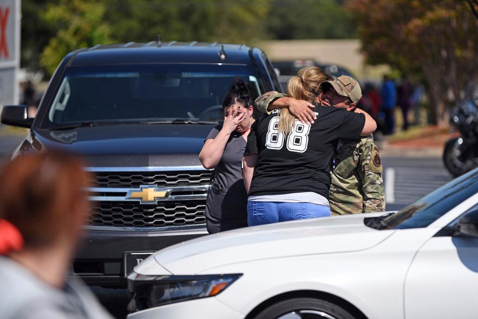 People console one another in an Academy Sports parking lot as police respond to an active shooter incident on Wednesday, Sept. 28, 2022, at the CHI St. Vincent North in Sherwood, Arkansas. One person killed and the suspect was arrested.