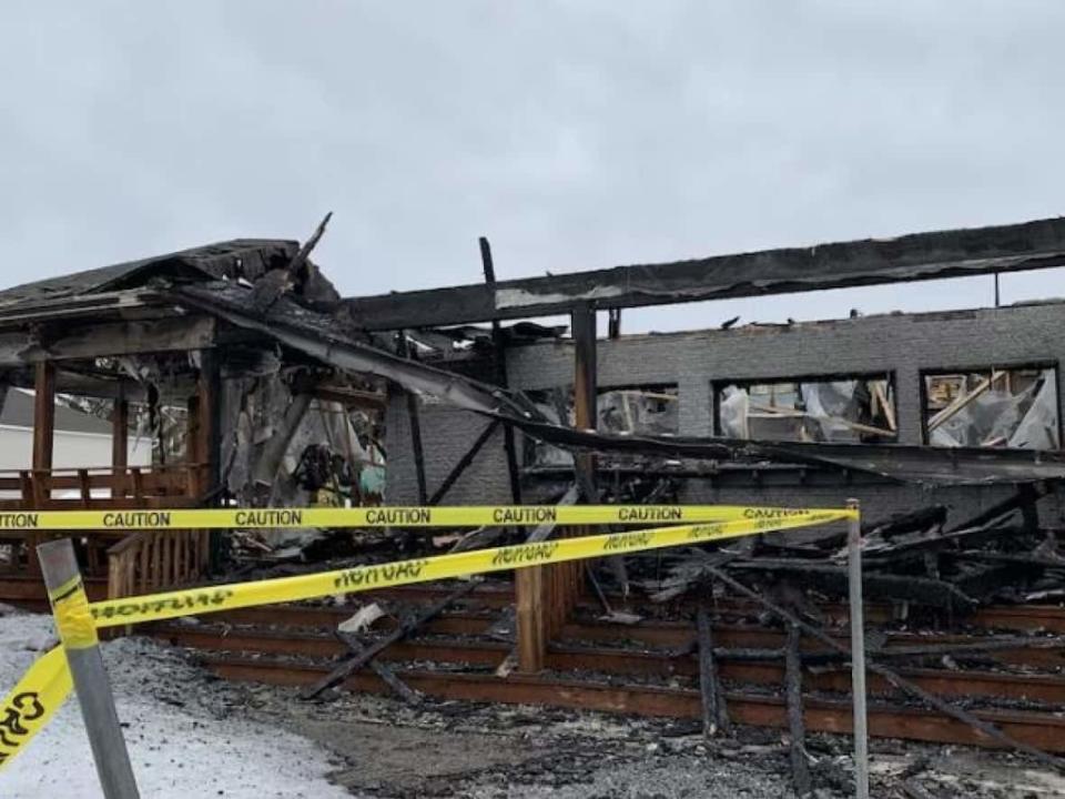 Tape is strung outside what remains of Les 2 Petits Cochons, a restaurant in Gatineau, Que., that was severely damaged by fire on March 24, 2023. (Rebecca Kwan/Radio-Canada - image credit)