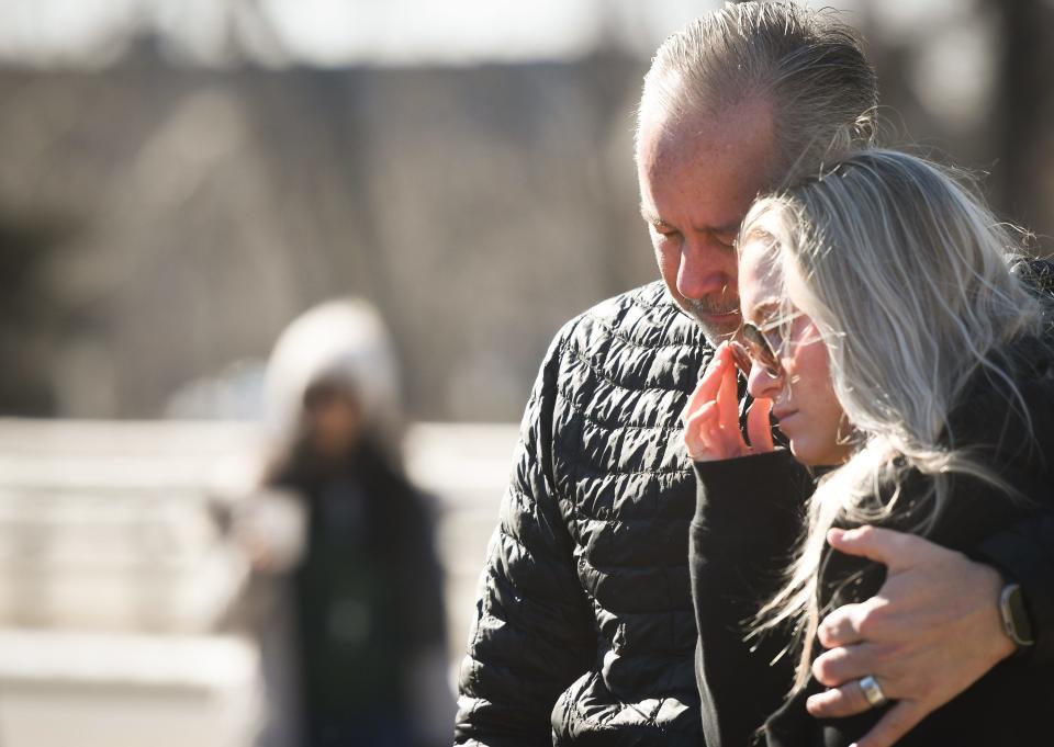 Doug Apple of Washington Township holds daughter and MSU student Abbey tight, Tuesday, Feb. 14, 2023, after she and friends placed flowers in front of "The Rock" at Michigan State University, to honor the victims of Monday's shooting on campus.