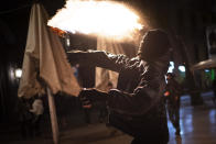 A protestor throws a molotov cocktail at police during clashes following a protest condemning the arrest of rap singer Pablo Hasél in Barcelona, Spain, Saturday, Feb. 27, 2021. After a few days of calm, protests have again turned violent in Barcelona as supporters for a jailed Spanish rapper went back to the streets. (AP Photo/Emilio Morenatti)