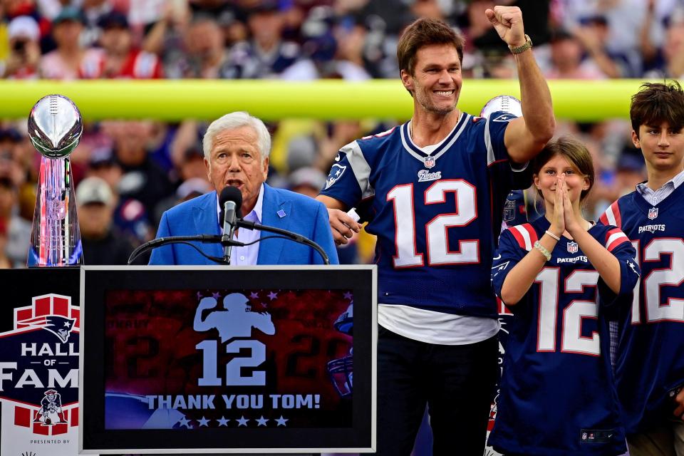 New England Patriots former quarterback Tom Brady gestures as New England Patriots owner Robert Kraft speaks during a halftime ceremony in his honor during the game between the Philadelphia Eagles and New England Patriots at Gillette Stadium.