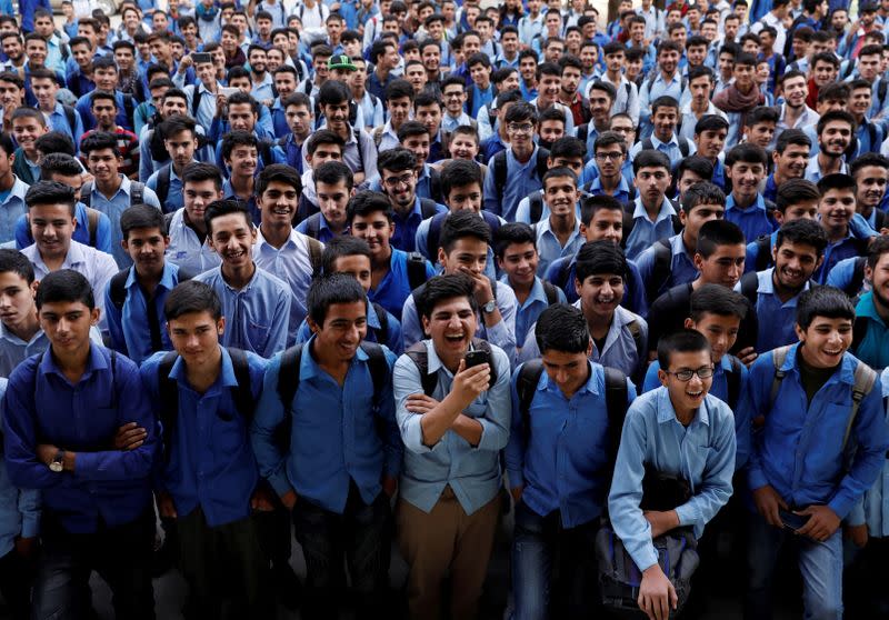 FILE PHOTO: Schoolboys watch Afghanistan's Charlie Chaplin, Karim Asir, 25, perform at a school in Kabul