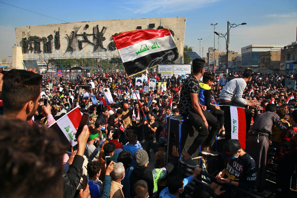 Followers of Shiite cleric Muqtada al-Sadr,gather in Tahrir Square, Baghdad, Iraq, Friday, Nov. 27, 2020. Thousands took to the streets in Baghdad on Friday in a show of support for a radical Iraqi cleric ahead of elections slated for next year, stirring fears of a spike in coronavirus cases. (AP Photo/Khalid Mohammed)