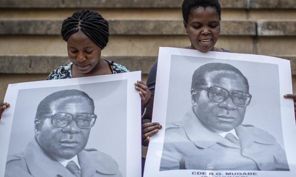 Women in the stands hold posters of the former president.