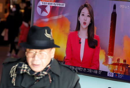 A man walks past a TV screen broadcasting a news report on North Korea firing a ballistic missile into the sea off its east coast, at a railway station in Seoul, South Korea, February 12, 2017. REUTERS/Kim Hong-Ji