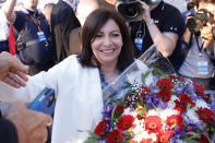 Paris mayor Anne Hidalgo gets a bouquet of flowers after her victorious second round of the municipal election, Sunday, June 28, 2020 in Paris. France on Sunday held the second round of municipal elections that has seen a record low turnout amid concerns over the coronavirus outbreak and anger at how President Emmanuel Macron's government handled it. (AP Photo/Christophe Ena)