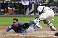 Chicago Cubs' Rafael Ortega slides safely past Milwaukee Brewers catcher Victor Caratini as he steals home during the sixth inning of a baseball game Tuesday, July 5, 2022, in Milwaukee. (AP Photo/Morry Gash)