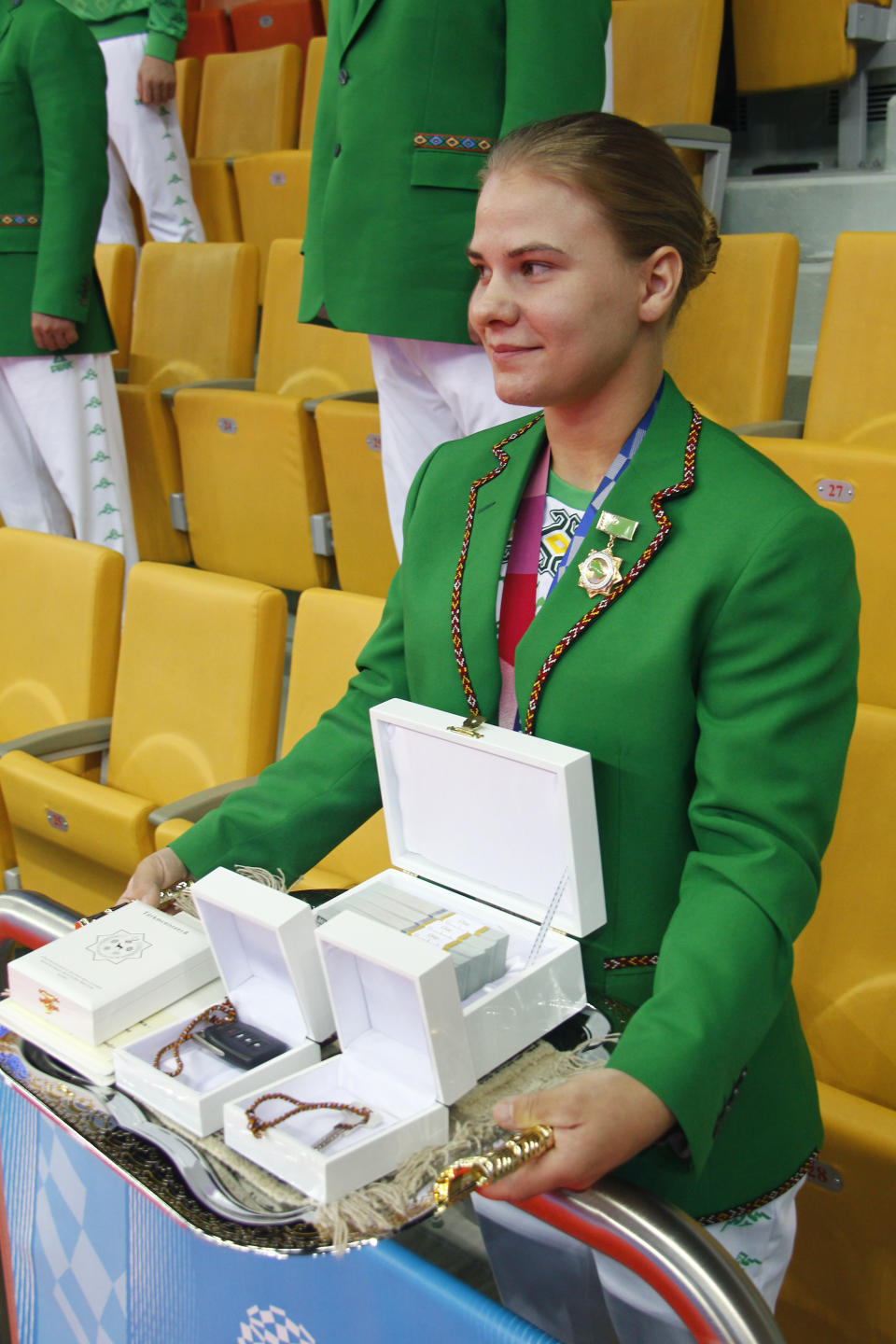 ADDS CLASS OF MEDAL Polina Guryeva, Olympic silver medalist in the women's 59kg weightlifting event, at the 2020 Summer Olympics shows her Presidential gift at a lavish ceremony in Ashgabat, Turkmenistan, Saturday, Aug. 21, 2021. Turkmenistan has lauded its first Olympic medal winner at a lavish ceremony where she was showered with gifts. Guryeva, 21, lifted a total 217 kilograms in the 59-kilogram category, edging Mikiko Andoh of Japan for second place at the Tokyo Games. (AP Photo/Alexander Vershinin)