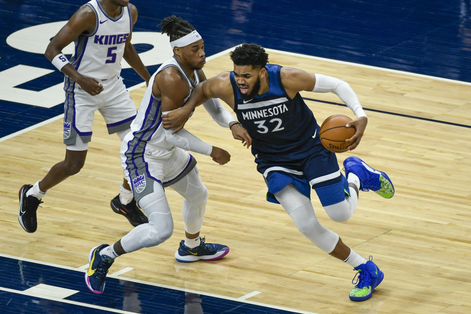 Minnesota Timberwolves center Karl-Anthony Towns (32) is fouled by Sacramento Kings center Richaun Holmes during the first half of an NBA basketball game Monday, April 5, 2021, in Minneapolis. (AP Photo/Craig Lassig)