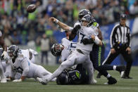 Tennessee Titans quarterback Ryan Tannehill (17) gets off an incomplete pass as he is tackled by Seattle Seahawks defensive end Rasheem Green, right, during the second half of an NFL football game, Sunday, Sept. 19, 2021, in Seattle. (AP Photo/John Froschauer)