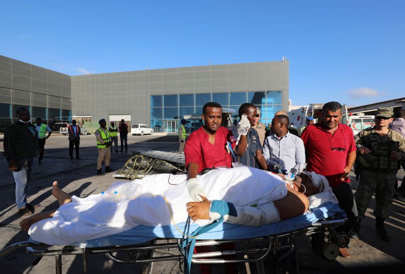 Paramedics assist a Turkish worker injured in an explosion in Afgoye town, as he boards a Turkish military cargo plane at the Aden Abdulle International Airport in Mogadishu