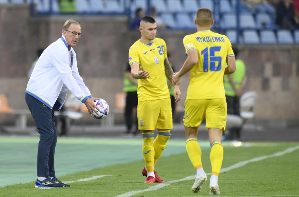 Ukraine's head coach Oleksandr Petrakov, left, holds the ball during the UEFA Nations League soccer match between Armenia and Ukraine at the Vazgen Sargsyan stadium in Yerevan, Armenia, Saturday, Sept. 24, 2022. (AP Photo/Hakob Berberyan)