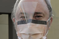 Dr. Stephen Anderson, who works in the Emergency Department at the MultiCare Auburn Medical Center in Auburn, Wash., wears a mask and face shield as he poses for a photo before starting his shift, Tuesday, March 17, 2020, in Auburn, Wash., south of Seattle. Anderson said he writes messages on his shields to identify them as his, and this morning he chose the phrase "Stay Safe." In the area that has led the country in coronavirus cases and also across the country, hospitals are gearing up for an onslaught of coronavirus patients, but staff on the front lines are stretched thin and don't have enough of the equipment they need to protect themselves from the highly contagious virus. (AP Photo/Ted S. Warren)