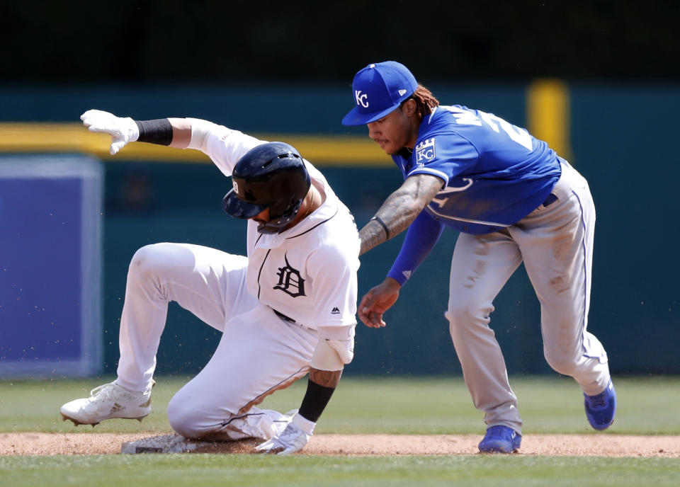 Detroit Tigers' Nicholas Castellanos beats the tag by Kansas City Royals second baseman Adalberto Mondesi (27) as he slides into second for a double during fifth inning of a baseball game, Saturday, April 6, 2019, in Detroit. (AP Photo/Carlos Osorio)