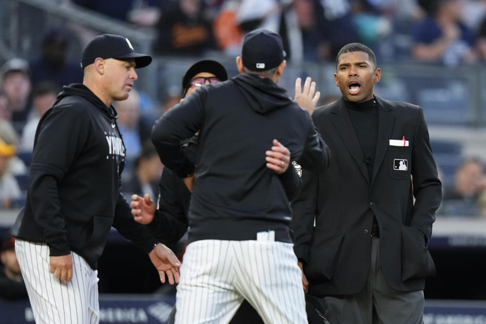 Home plate umpire Edwin Moscoso, right, talks to New York Yankees manager Aaron Boone as Boone is restrained after being ejected during the third inning of the team's baseball game against the Baltimore Orioles on Thursday, May 25, 2023, in New York. (AP Photo/Frank Franklin II)