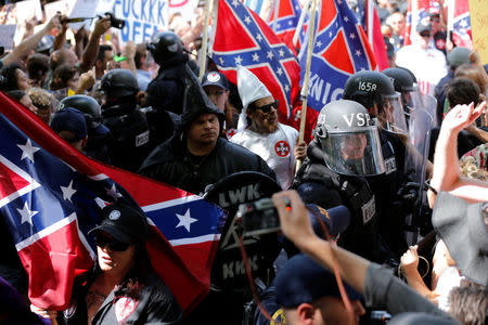 Riot police protect members of the Ku Klux Klan from counter-protesters as they arrive to rally in opposition to city proposals to remove or make changes to Confederate monuments in Charlottesville, Virginia, U.S. July 8, 2017. REUTERS/Jonathan Ernst