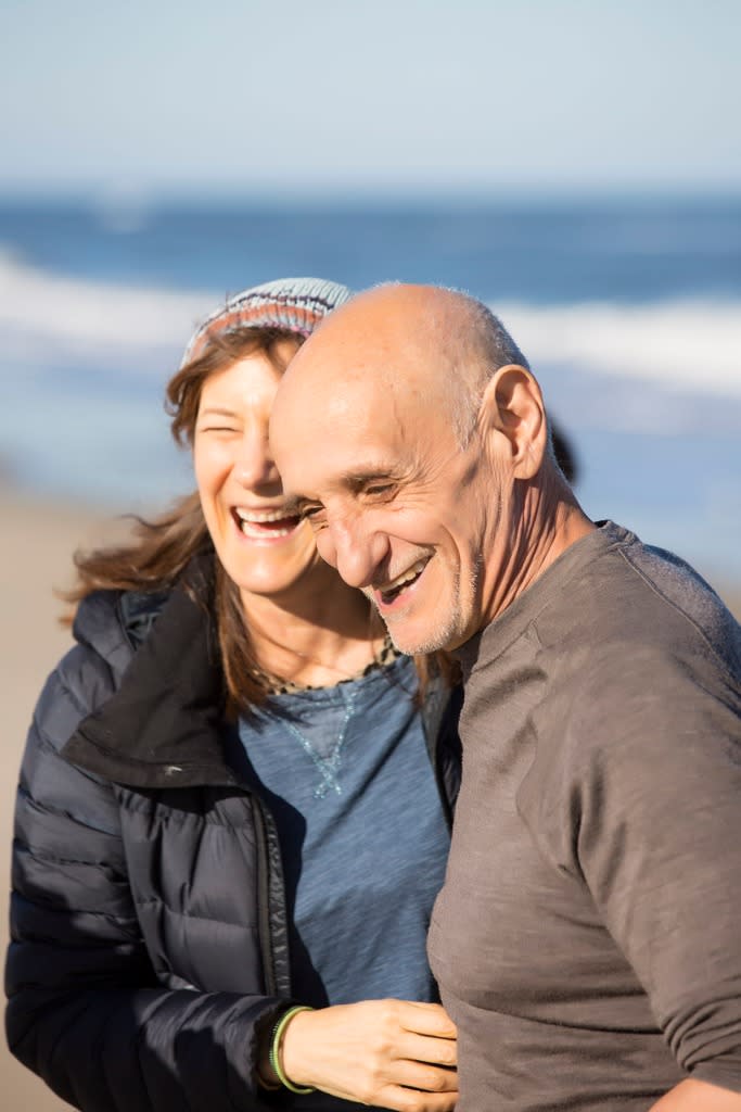 A picture of a woman and man smiling by the ocean