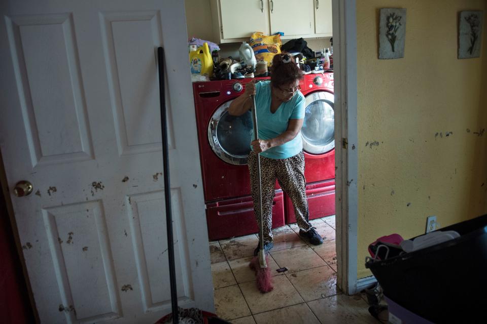 A woman cleans the floors of a once flooded house in Houston. (Photo: BRENDAN SMIALOWSKI/AFP/Getty Images)