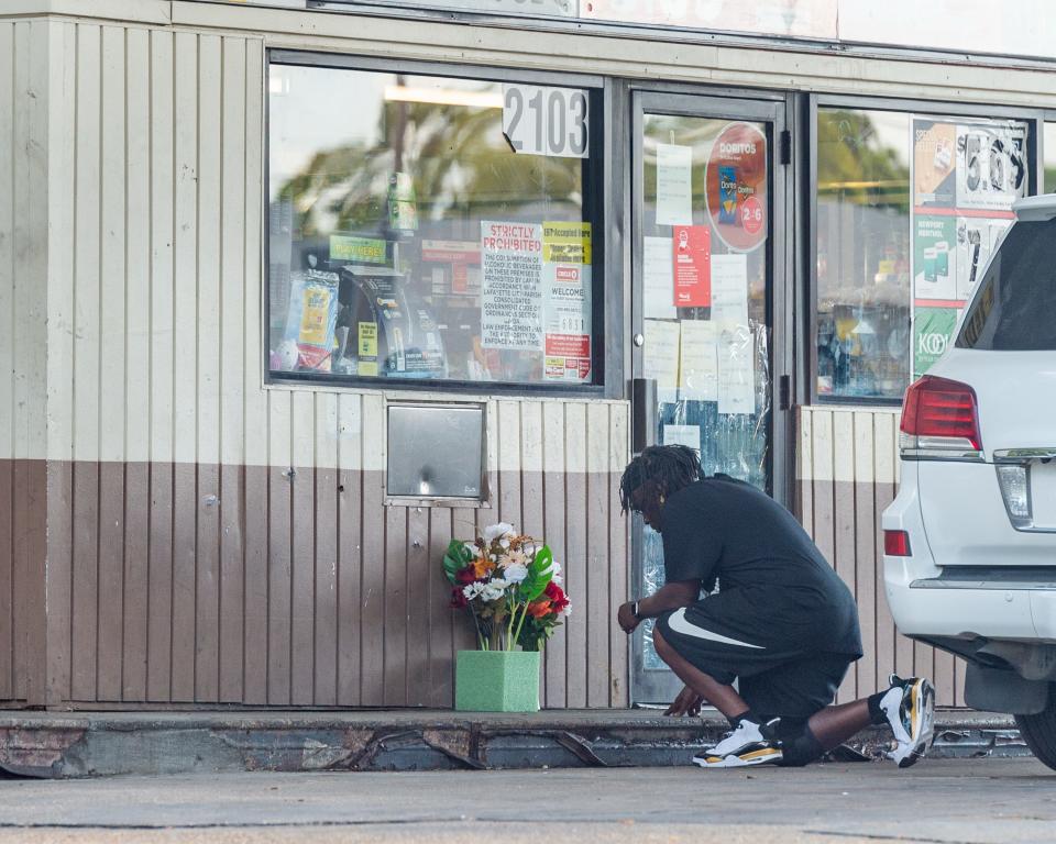 A man kneels to say a prayer outside convenience store on Evangeline Thruway where a man was shot and killed by Lafayette Police. Saturday, Aug. 22, 2020.