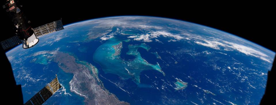 panorama photo shows deep blue Caribbean sea with brown green islands stretching across the curvature of the earth