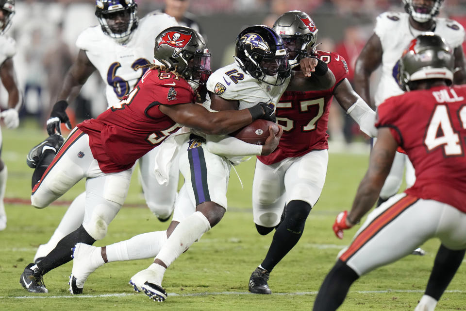 Baltimore Ravens quarterback Anthony Brown (12) is stopped by Tampa Bay Buccaneers linebacker J.J. Russell (51) and linebacker Ulysees Gilbert during the second half of an NFL preseason football game Saturday, Aug. 26, 2023, in Tampa, Fla. (AP Photo/Chris O'Meara)