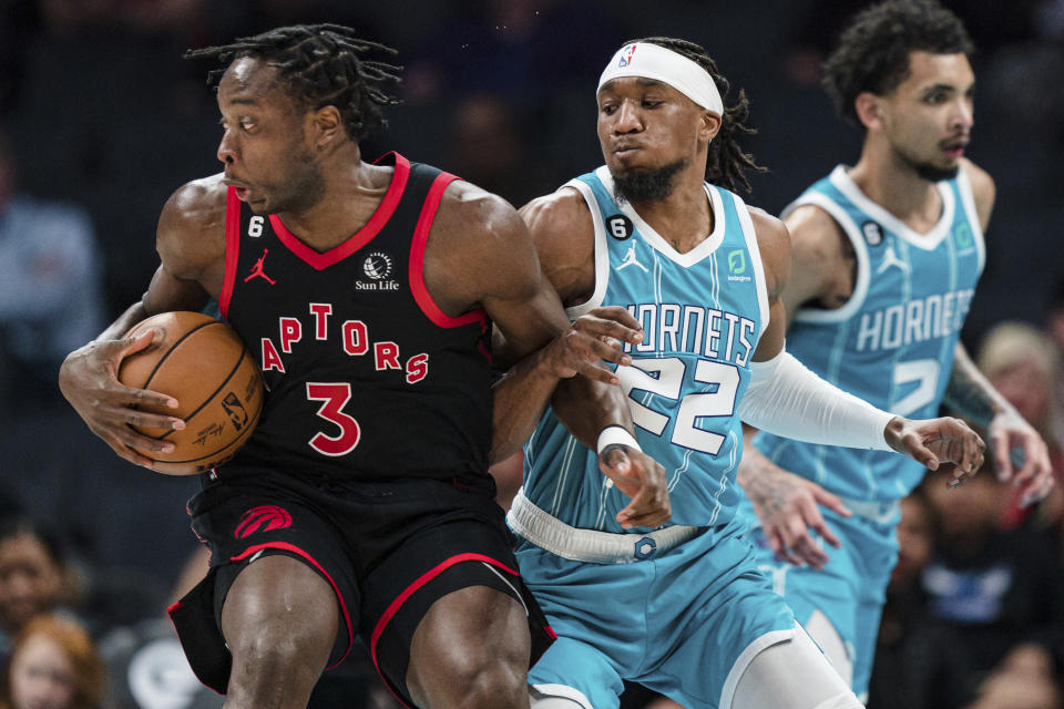 Charlotte Hornets forward Xavier Sneed (22) guards Toronto Raptors forward O.G. Anunoby (3) during the first half of an NBA basketball game in Charlotte, N.C., Tuesday, April 4, 2023. (AP Photo/Jacob Kupferman)