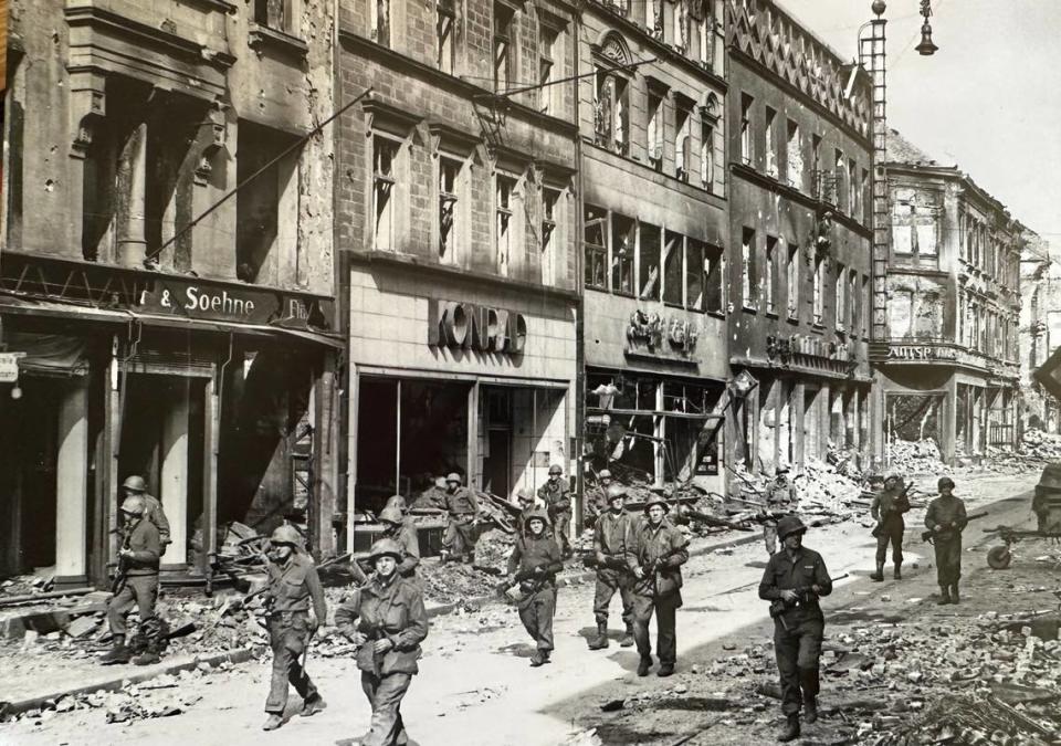 Soldados de la 70ª División de Infantería del Ejército de Estados Unidos buscan francotiradores mientras avanzan por las calles de Saarbrucken, Alemania, durante la Segunda Guerra Mundial. U.S. Army photo