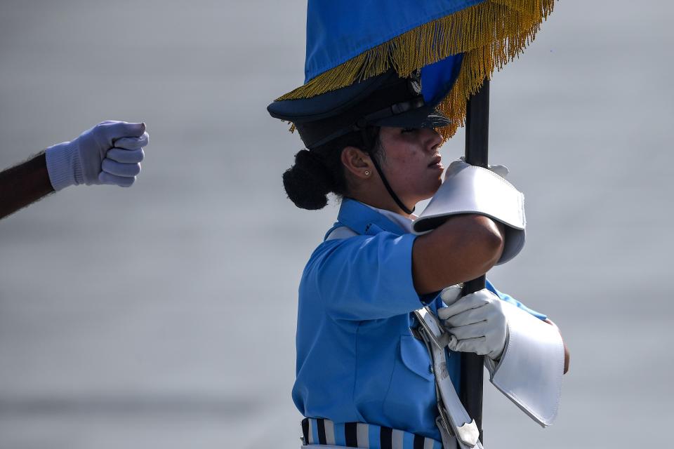 An Indian Air Force (IAF) soldier holds the Indian Air Force flag as she marches during the 88th Air Force Day parade at Hindon Air Force station in Ghaziabad on October 8, 2020. (Photo by Money SHARMA / AFP) (Photo by MONEY SHARMA/AFP via Getty Images)