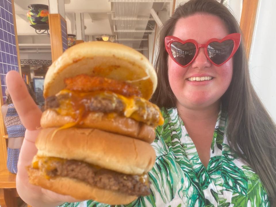 guy's burger joint Megan duBois holding up burger smiling