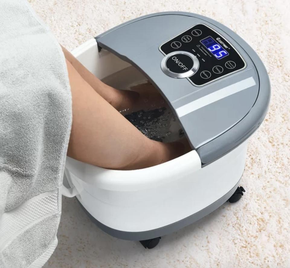 A person's feet in a portable foot spa machine for relaxation and pedicure treatments