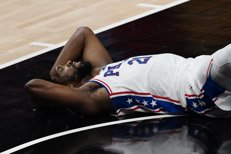 Philadelphia 76ers center Joel Embiid (21) lies on the floor after being called for a foul during the first half of Game 6 of an NBA basketball Eastern Conference semifinal series against the Atlanta Hawks, Friday, June 18, 2021, in Atlanta. (AP Photo/John Bazemore)