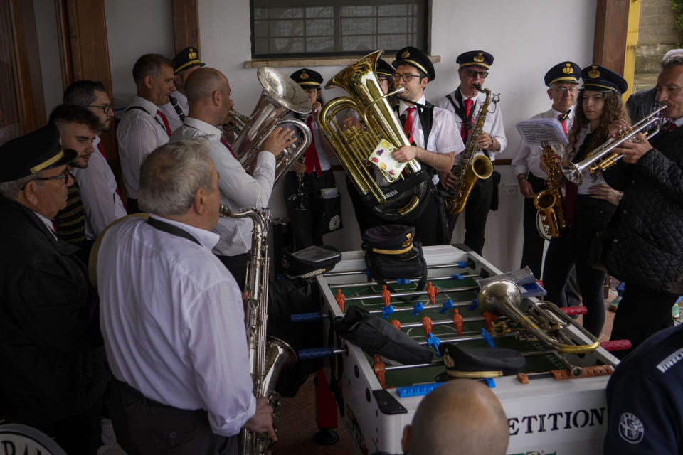 Agostino Tatulli, center, plays with his band in Forca di Valle, near Teramo in central Italy, Monday, June 5, 2023. For Tatulli, a way to find meaning is music, including gigs with a marching band for the popular feasts of patron saints. This summer, he participated in two such processions over 48 hours. A weekday morning one was cut short by a rainstorm in the hamlet of Forca di Valle, high on the forested mountain ridge above Isola del Gran Sasso. (AP Photo/Domenico Stinellis)