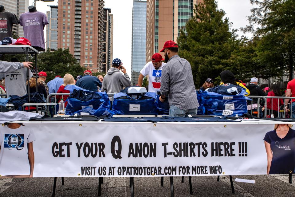 A vendor sells Qanon shirts ahead of a rally with U.S. President Donald Trump and Senator Ted Cruz, a Republican from Texas, in Houston, Texas, U.S., on Monday, Oct. 22, 2018. Trump's approval rating is split, even in red-state Texas, where Cruz faces an unexpectedly strong challenge from Democrat Beto O'Rourke. Photographer: Sergio Flores/Bloomberg via Getty Images