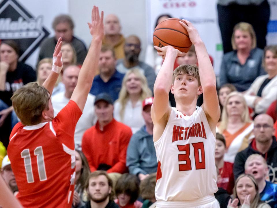 Metamora's Cooper Koch (30) lines up a three-pointer over Morton's Gus Rugaard in the first half of their Mid-Illini Conference basketball game Tuesday, Jan. 23, 2024 in Metamora. The Redbirds defeated the Potters 67-48.